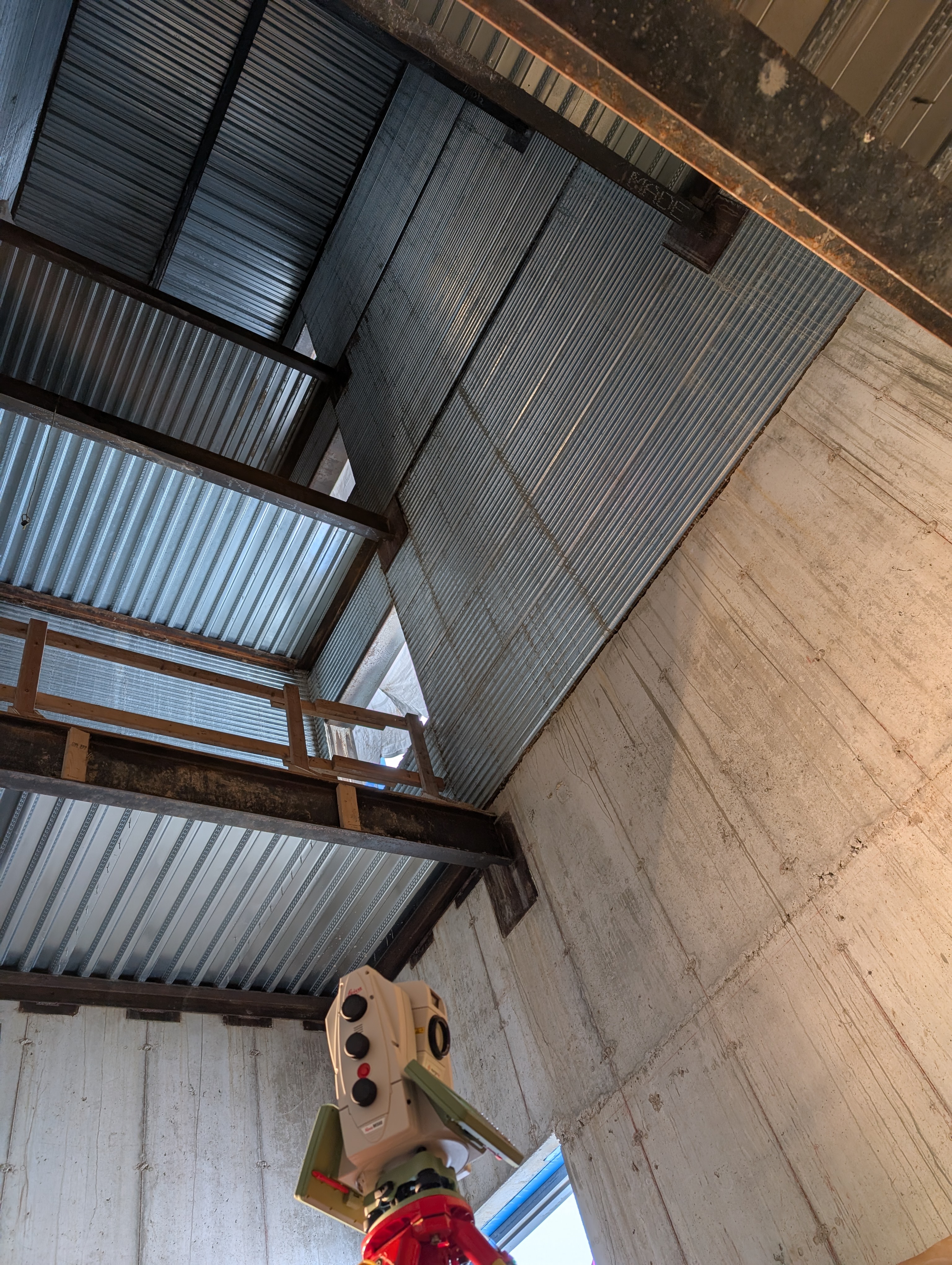 Leica scanner inside a Metalcon building, looking up at corrugated steel roof structure